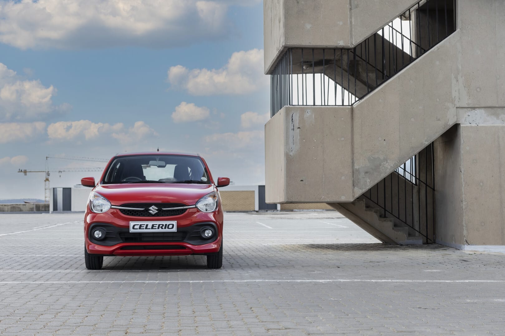 Red Suzuki Celerio next to a flight of stairs