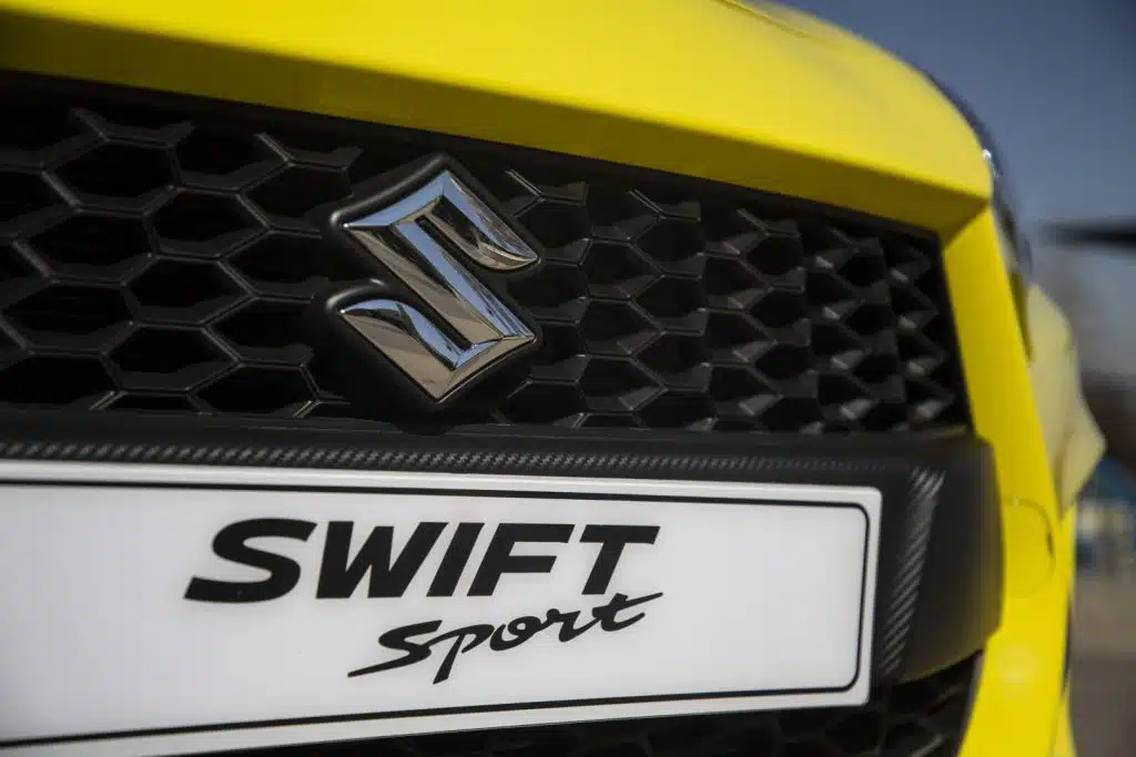 Yellow Suzuki Swift Sport Close up on Suzuki Badge and Grille