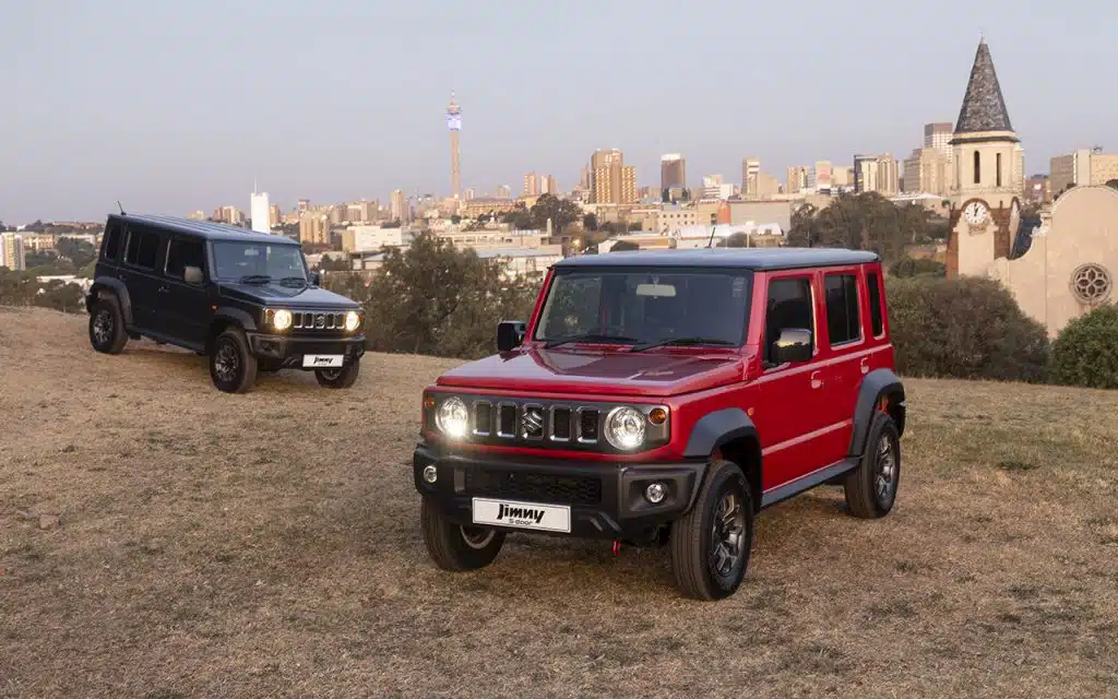 Two Suzuki Jimny's 5-door. A red and black model.